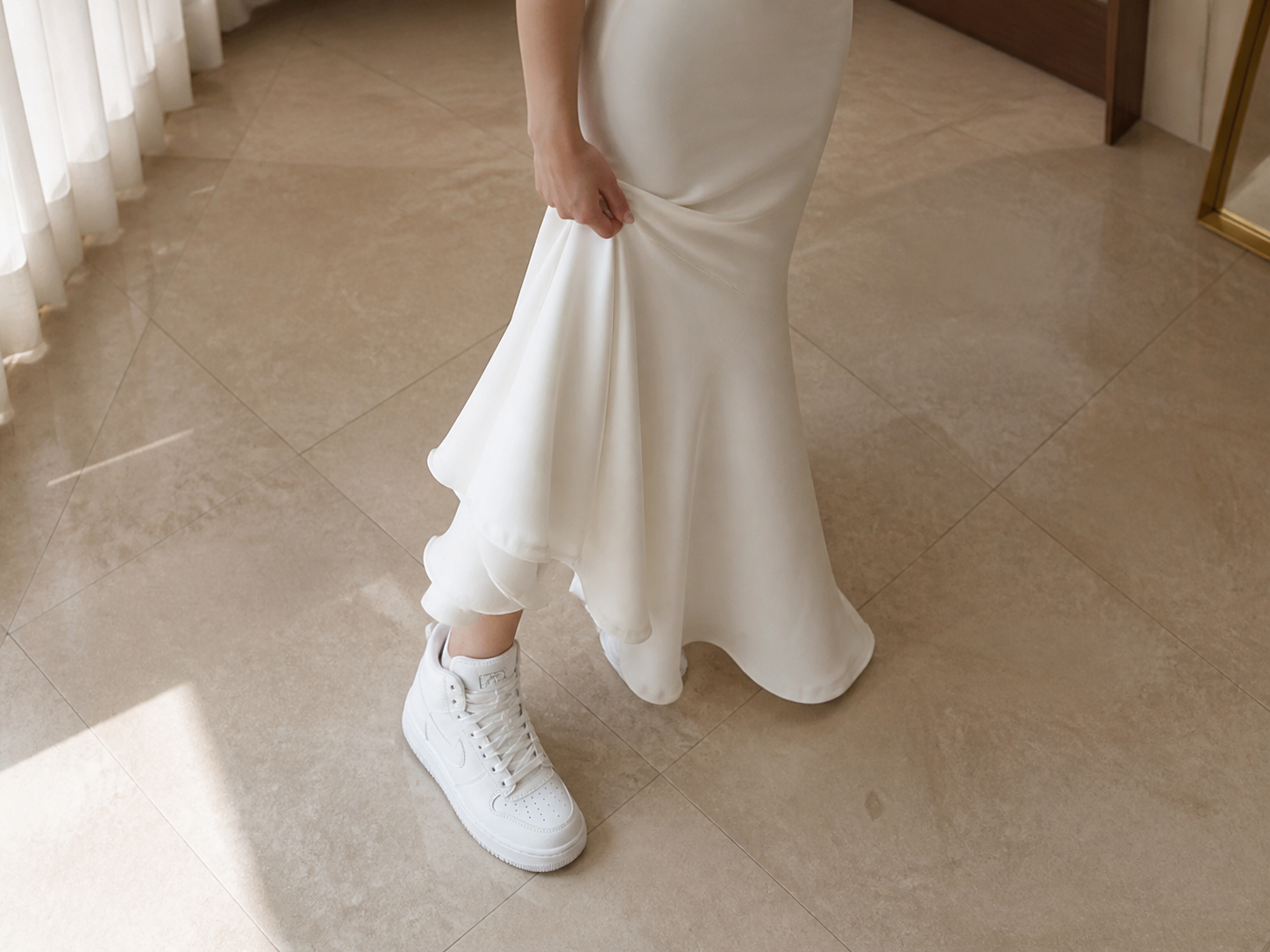 Gaya padu padan Ahn Yu-jin, memadukan gaun mermaid putih yang elegan dengan sepatu kets high-top putih yang nyaman.