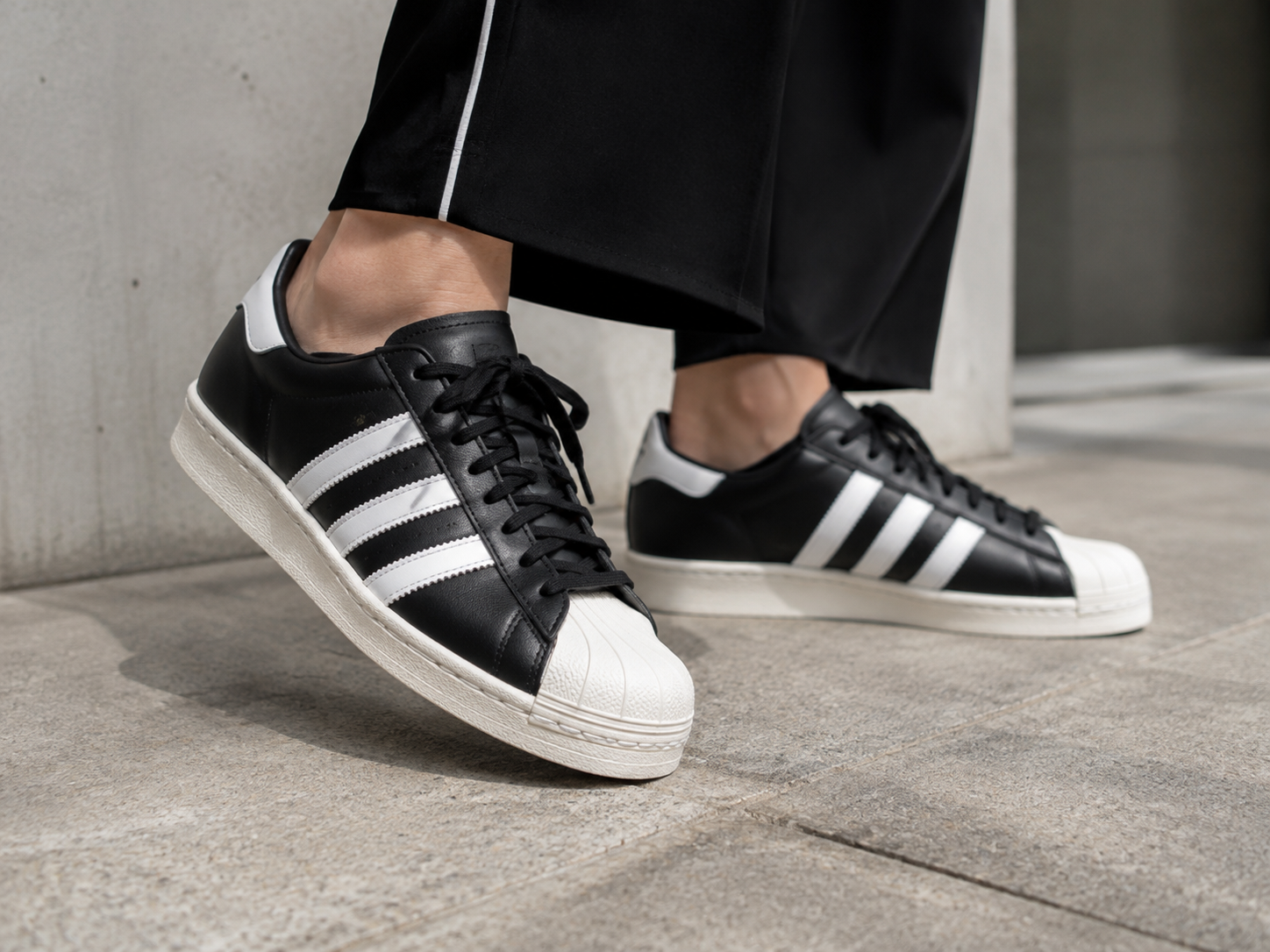 The black and white Adidas Superstar 2 sneakers and track top skirt outfit worn by Jennie