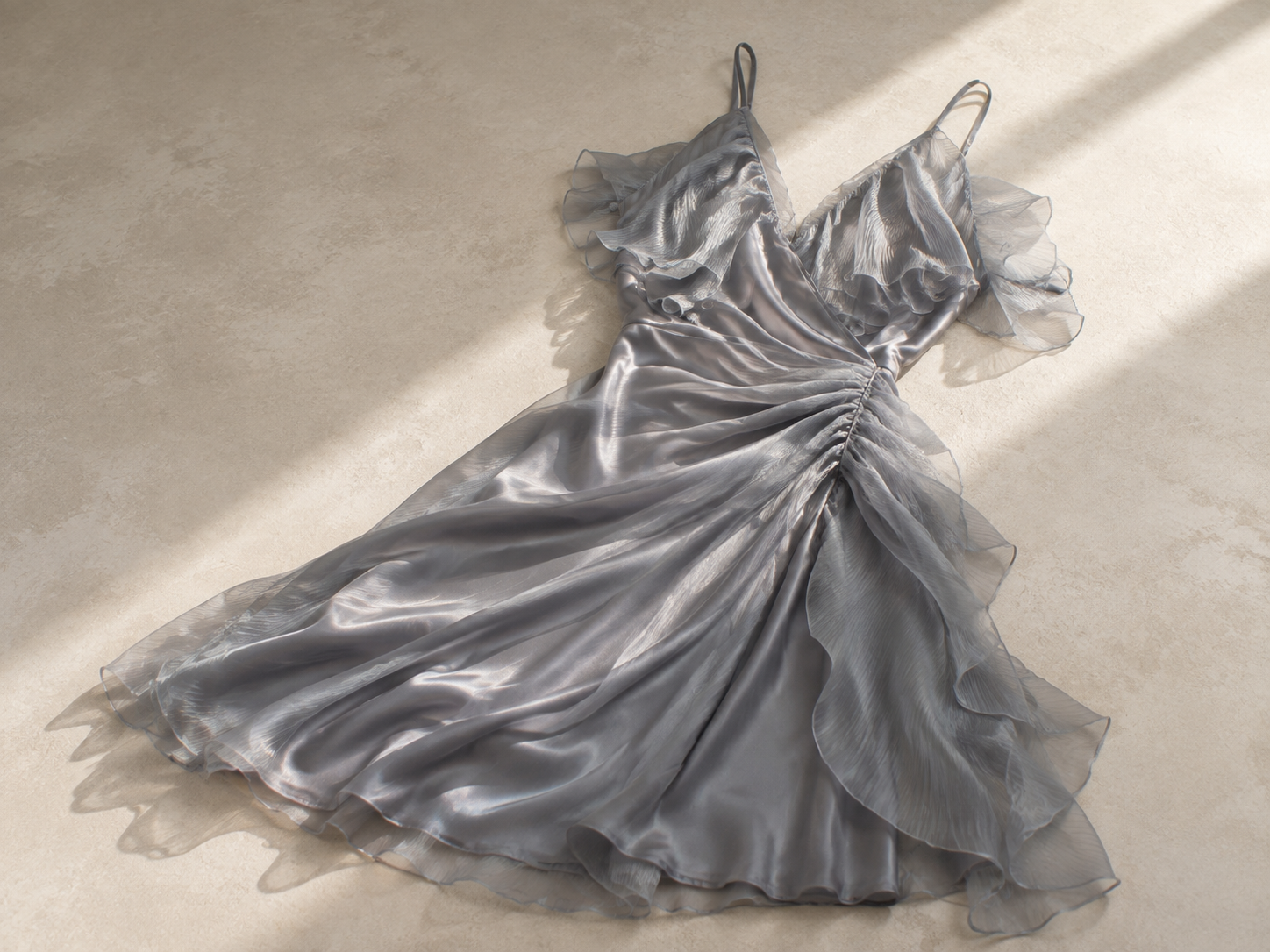 安恩真身穿的灰色吊带裙，裙摆层叠的薄纱荷叶边和褶裥，通过光影营造出立体效果。